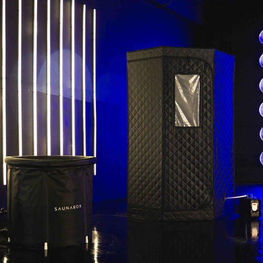 Black sauna tent with quilted design and 'SAUNABOX' branding against a blue wall.