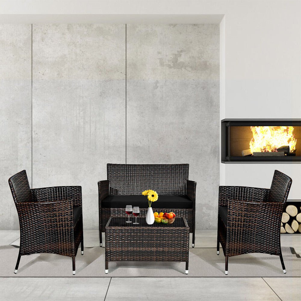 Outdoor furniture set with chairs and a table in front of a fireplace.