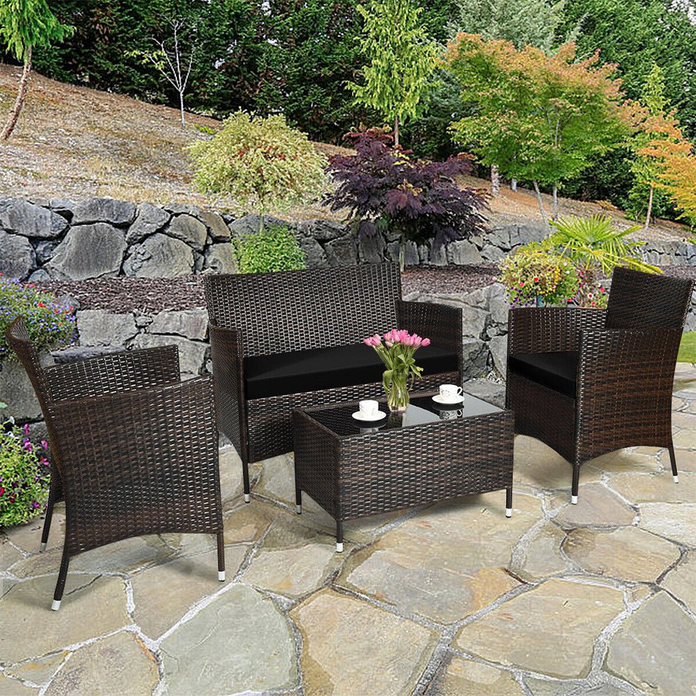 Outdoor patio set with wicker chairs and table on a stone patio