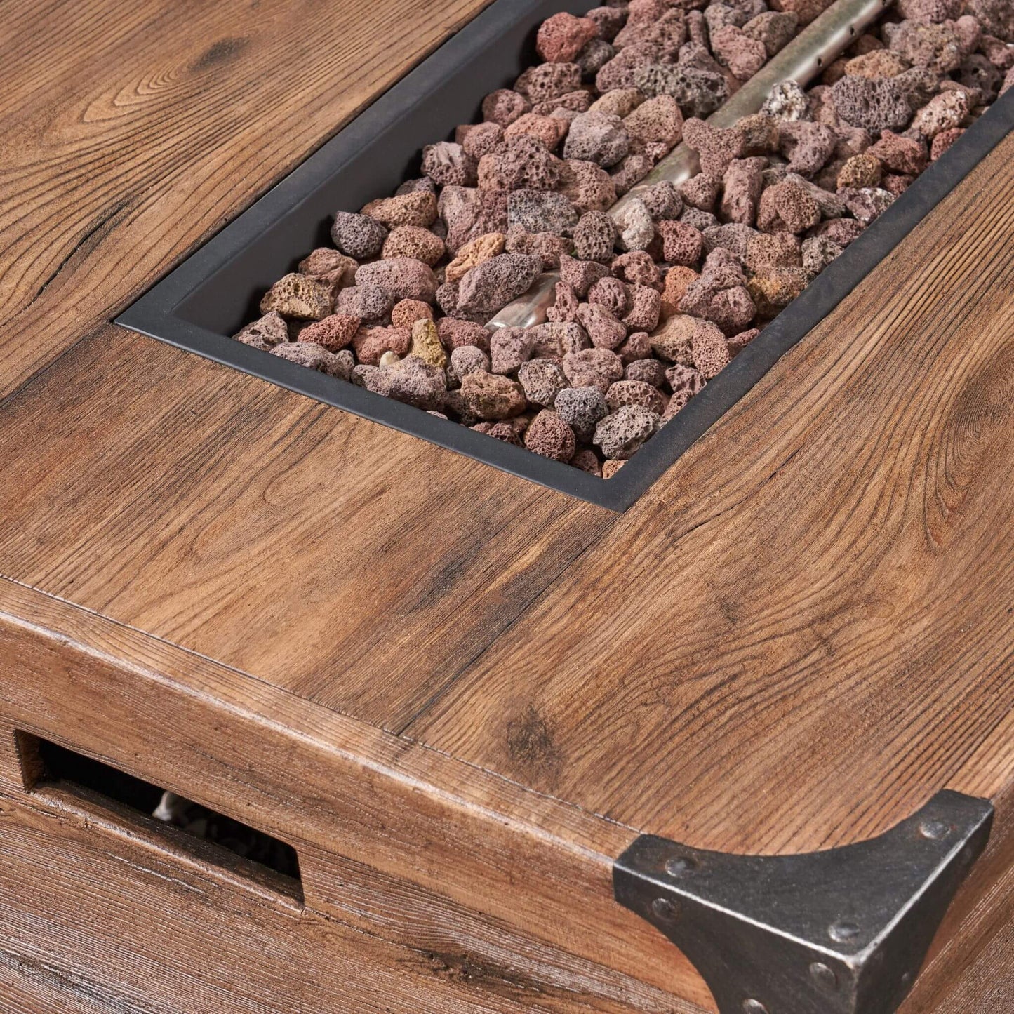 Wooden table with a fire pit insert containing rocks