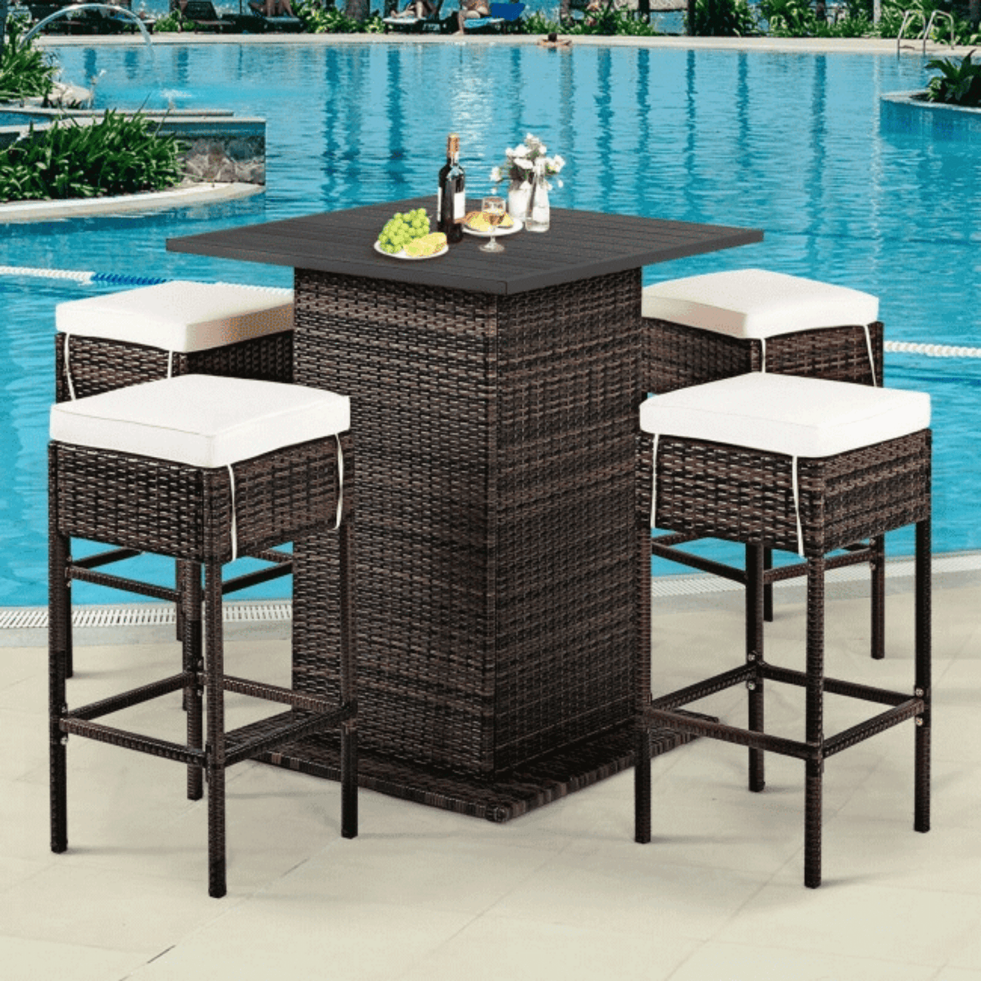 Outdoor patio set with a high table and stools by a pool