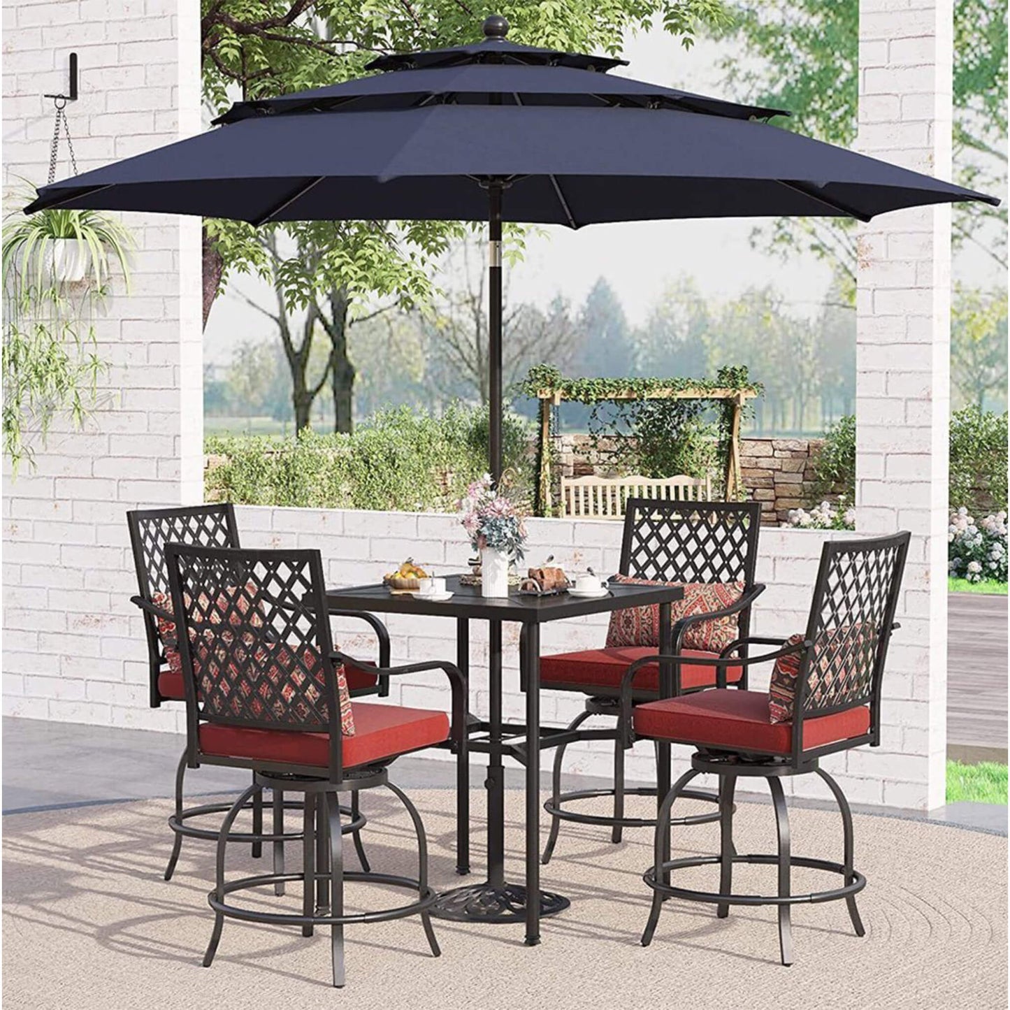 Outdoor patio set with table and chairs under a large umbrella on a patio.