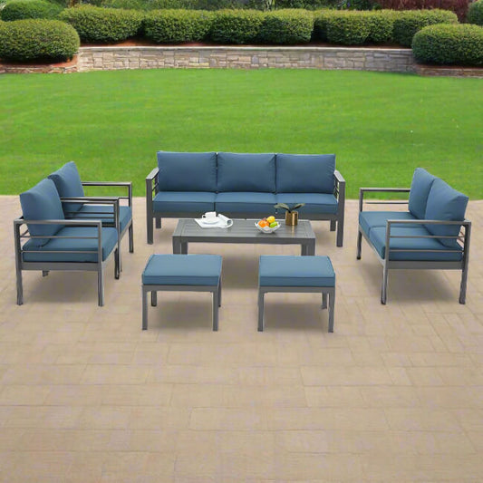 Outdoor patio furniture set with blue cushions on a paved patio.