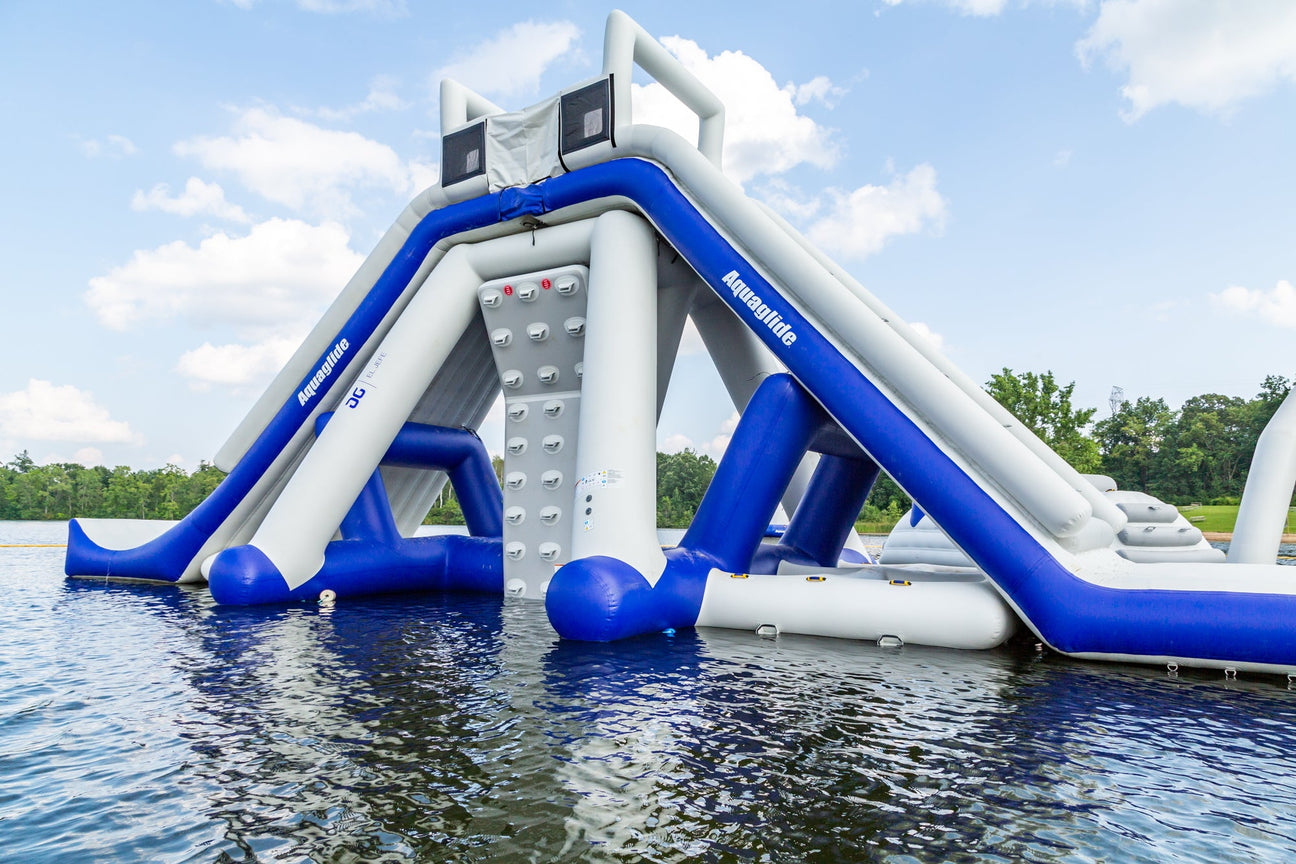 Aquaglide Signature Aquapark Features, including bouncers and trampolines, set up in an open water lake for fun and excitement.