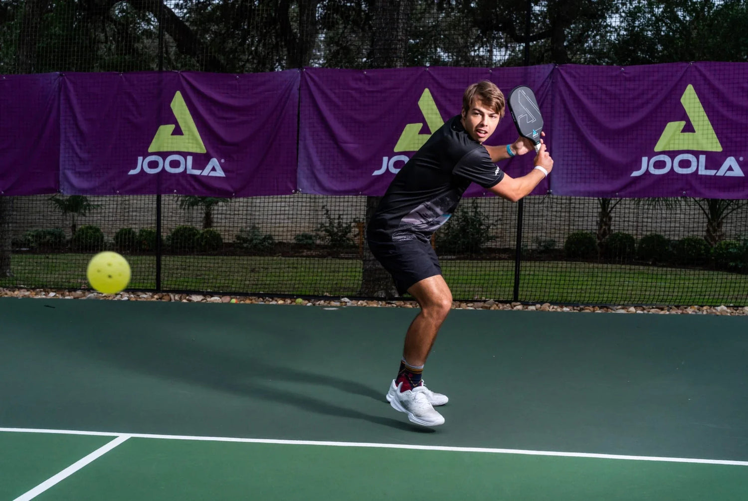 Man playing pickleball on court using JOOLA paddle and gear, showcasing JOOLA's premium pickleball equipment for optimal performance