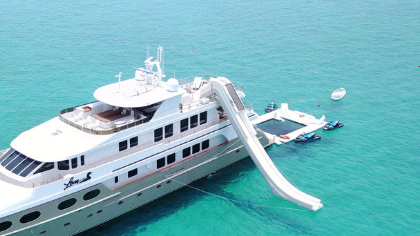 Docking Station, a 14 ft platform, docking water toys near a yacht, showcasing a yacht waterpark accessory.