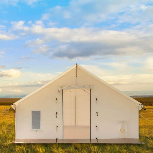 Beige camping tent in a grassy field with a blue sky and clouds