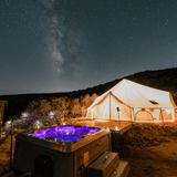 Tent and hot tub under a starry night sky with the Milky Way visible.