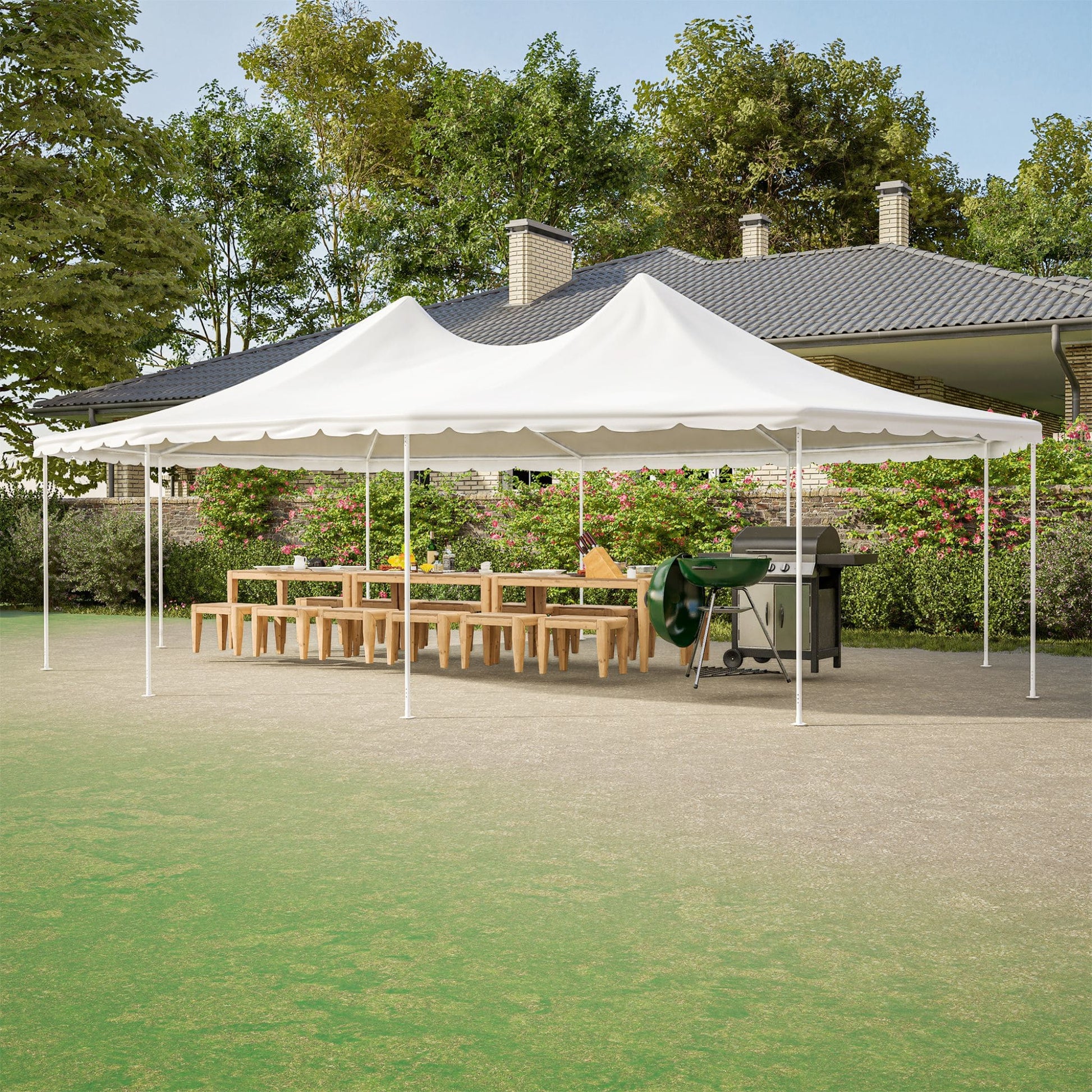 White outdoor canopy tent set up in a backyard with a table and grill underneath.
