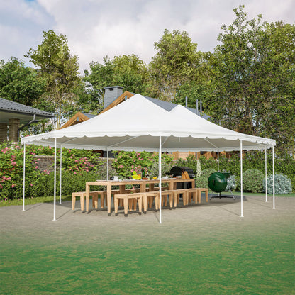 White outdoor canopy tent set up in a garden with tables and chairs underneath.