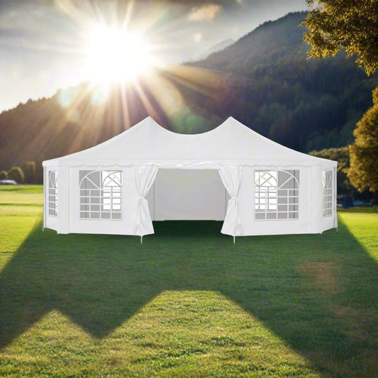 White outdoor canopy tent set up on a grassy area with mountains in the background