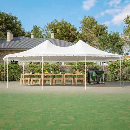 White outdoor canopy tent set up on a grassy area with a house and trees in the background.