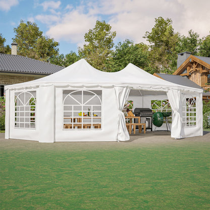 White outdoor canopy tent with curtains set up in a garden area with trees and houses in the background.