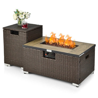 Outdoor fire pit table with wicker design and a small table on top holding a glass of red wine and flowers.