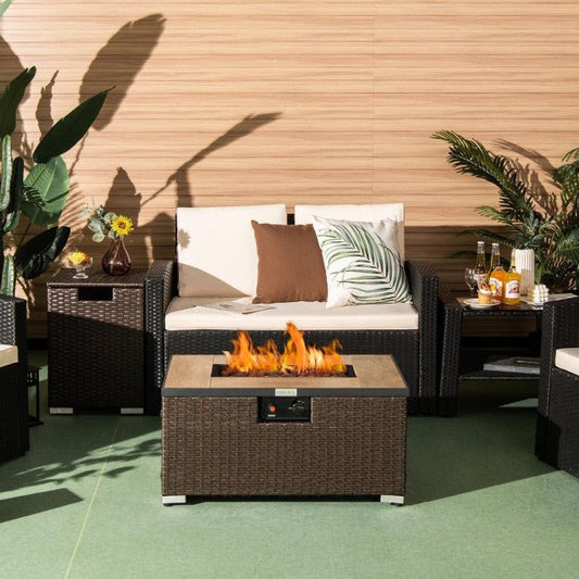 Outdoor patio setting with a fire pit table, sofa, and decorative elements.