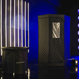 Black sauna tent with quilted design and 'SAUNABOX' branding against a blue wall.
