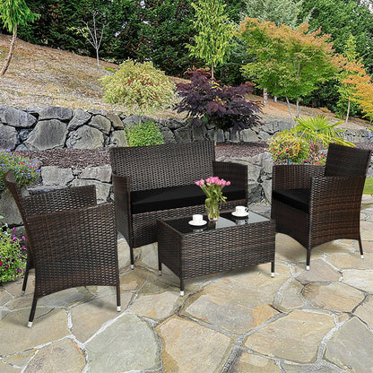 Outdoor patio set with wicker chairs and table on a stone patio