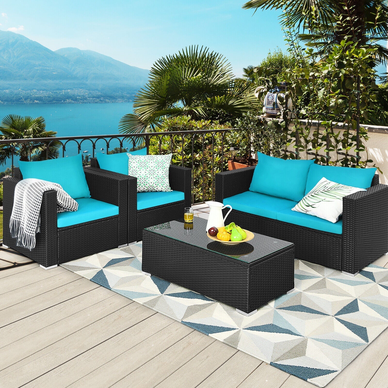 Outdoor patio set with blue cushions and a coffee table on a deck with scenic background.