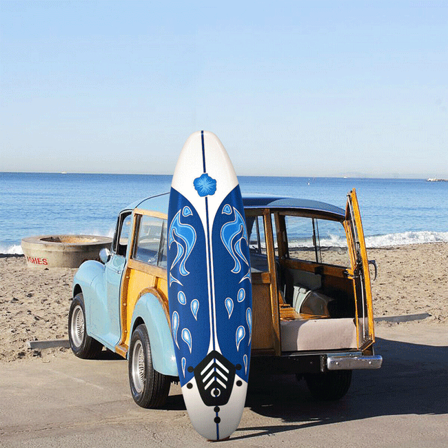 Blue and white surfboard with a wooden vehicle on a beach