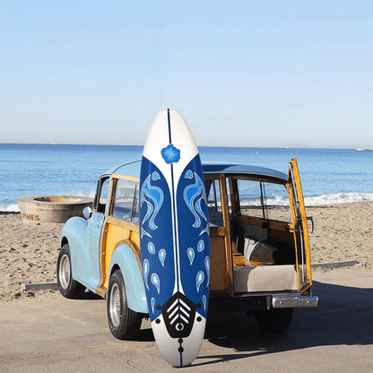 Blue and white surfboard with a wooden vehicle on a beach