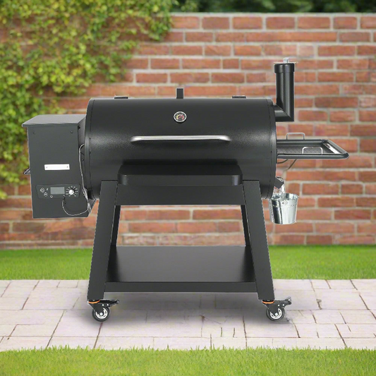 Black barbecue grill on wheels with a brick wall and greenery in the background