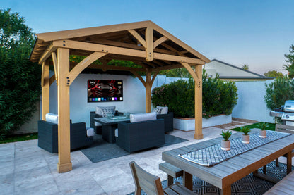 Wooden pergola with outdoor furniture and MirageVision Outdoor TV screen in a backyard setting