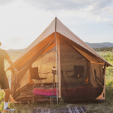 Camping tent with interior furniture in a natural setting