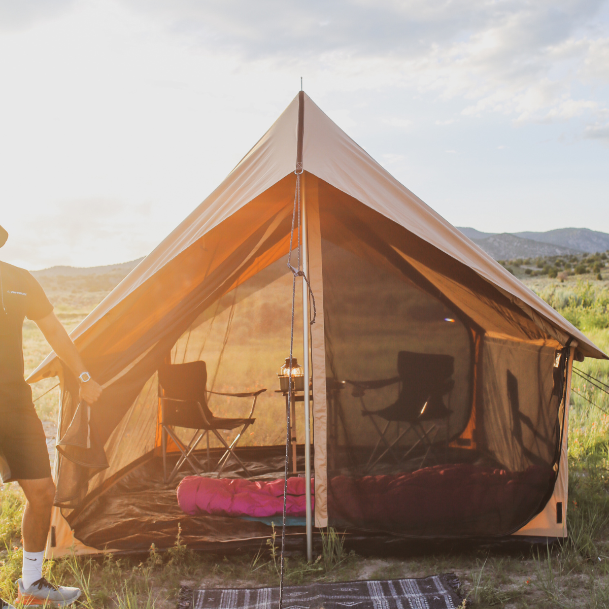 Camping tent with interior furniture in a natural setting