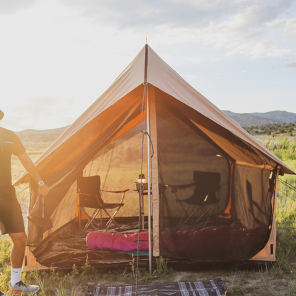 Camping tent with interior furniture in a natural setting