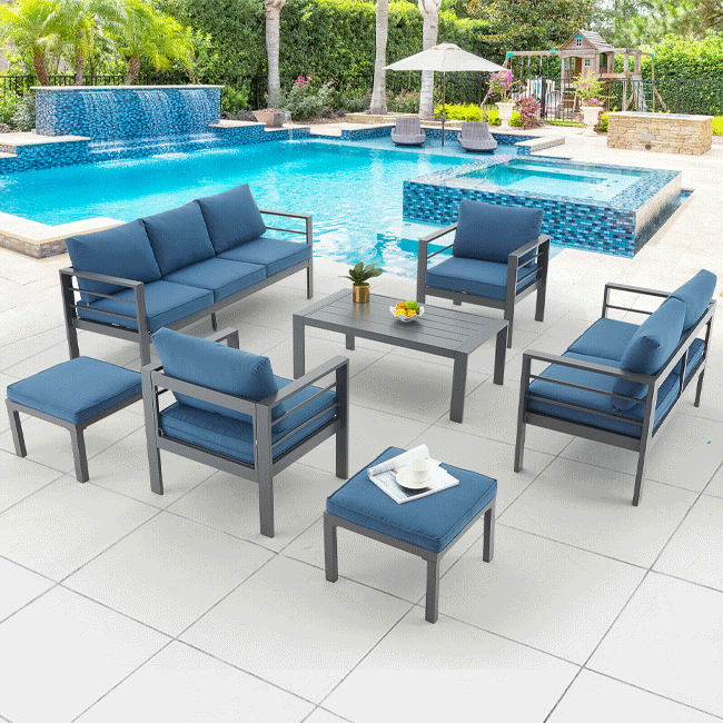 Outdoor patio furniture set with blue cushions by a pool