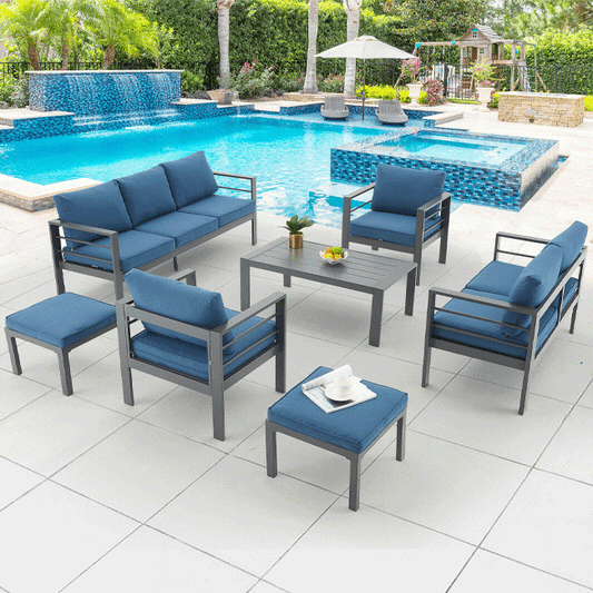 Outdoor patio furniture set with blue cushions by a pool