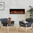 Two dogs sitting on gray chairs in front of a modern electric fireplace.