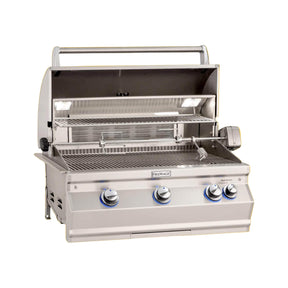 A built-in Fire Magic Aurora Multi-User Built-In Grill with analog thermometer and rotisserie kit, featuring stainless steel construction and blue control knobs, against an orange background.