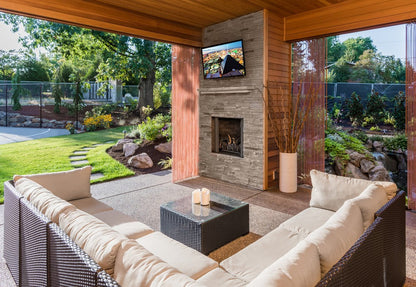 Outdoor living space with patio furniture, fireplace, and television.