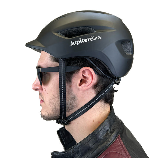 Person wearing a black Jupiter Bike helmet on a white background