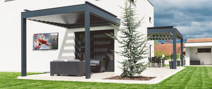 Patio area with pergola, outdoor smart TV, and a tree on a grassy lawn.