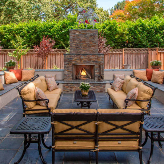 Outdoor patio with fireplace, furniture, and decorative elements in a garden setting.