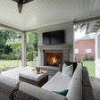 Outdoor patio with fireplace, TV, and comfortable seating area.