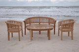 Wooden outdoor furniture set on a sandy beach with ocean waves in the background