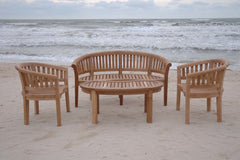 Wooden outdoor furniture set on a sandy beach with ocean waves in the background