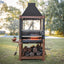 Outdoor barbecue grill with wood storage on a grassy area