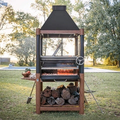Outdoor barbecue grill with wood storage on a grassy area