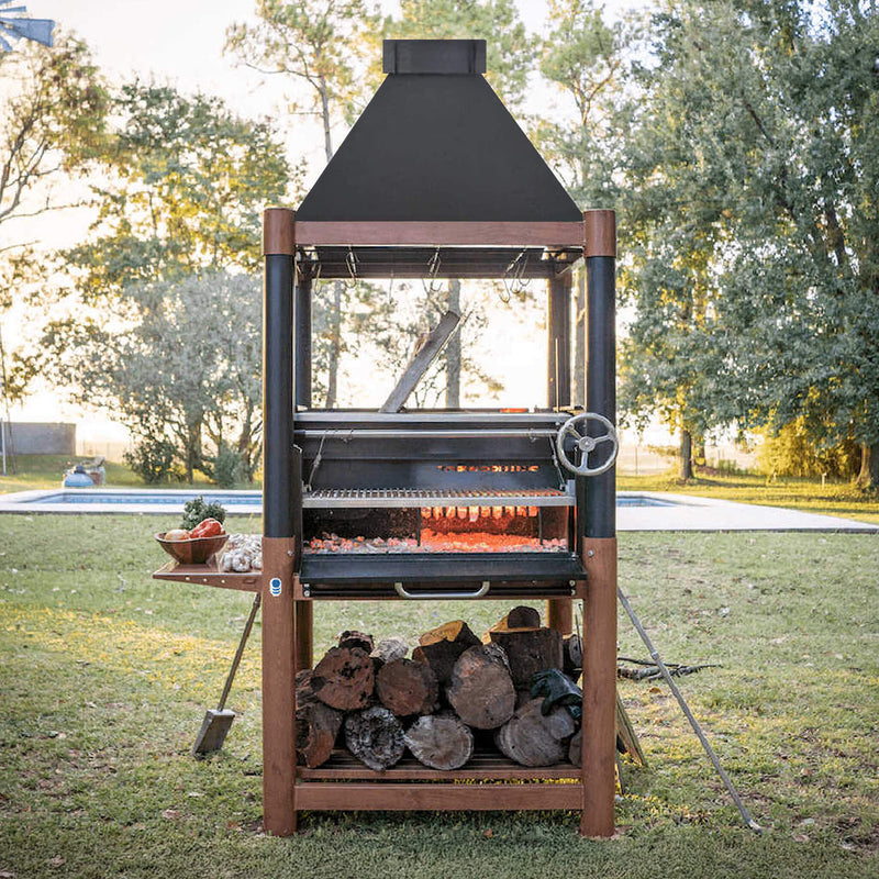 Outdoor barbecue grill with wood storage on a grassy area